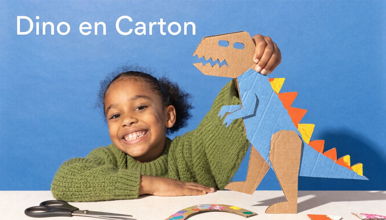 Une jeune fille souriante assemble un dinosaure en carton coloré sur une table bleue devant elle.