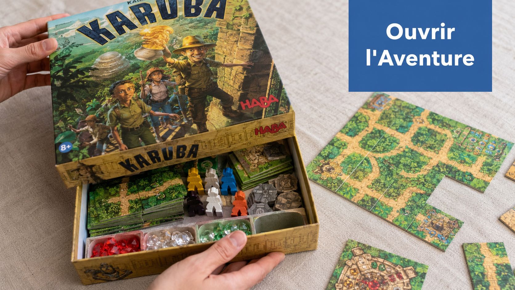 Une personne ouvre la boîte du jeu de société Karuba posée sur une table en lin clair.